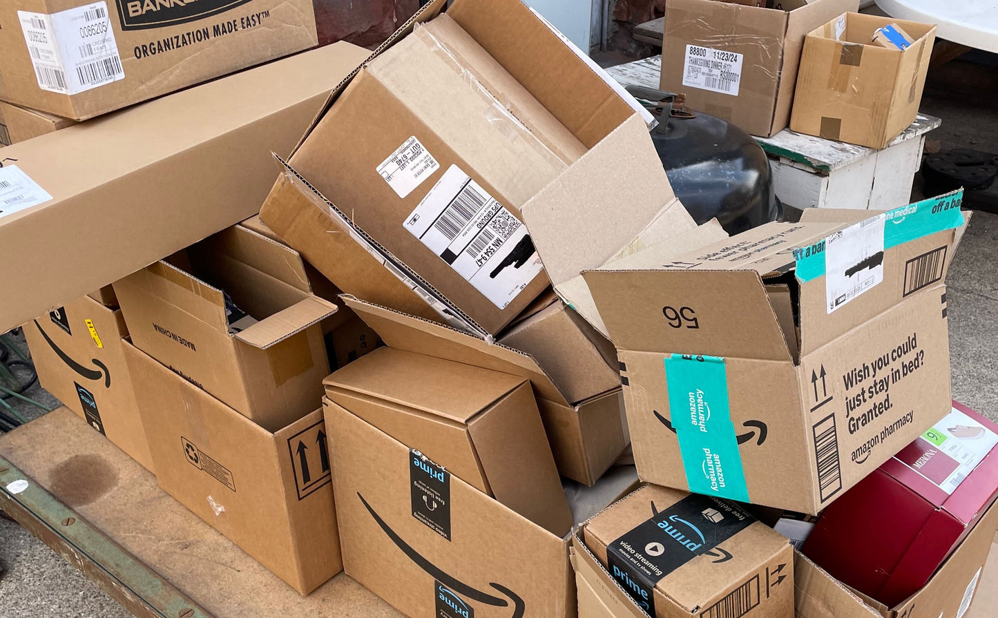 Stack of cardboard boxes on a cart outside a house