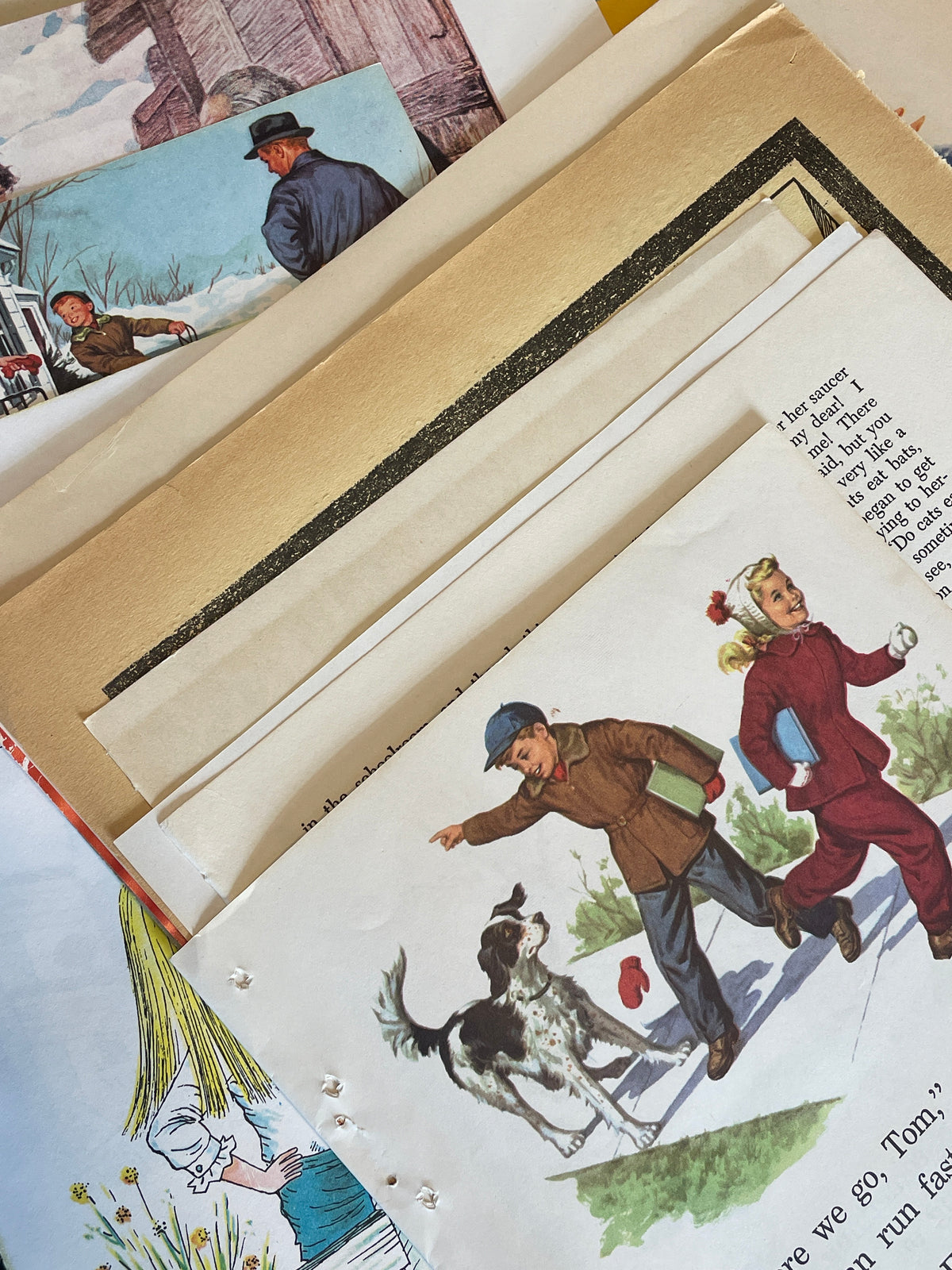 Stacked children's book pages with an illustration of people skiing on top