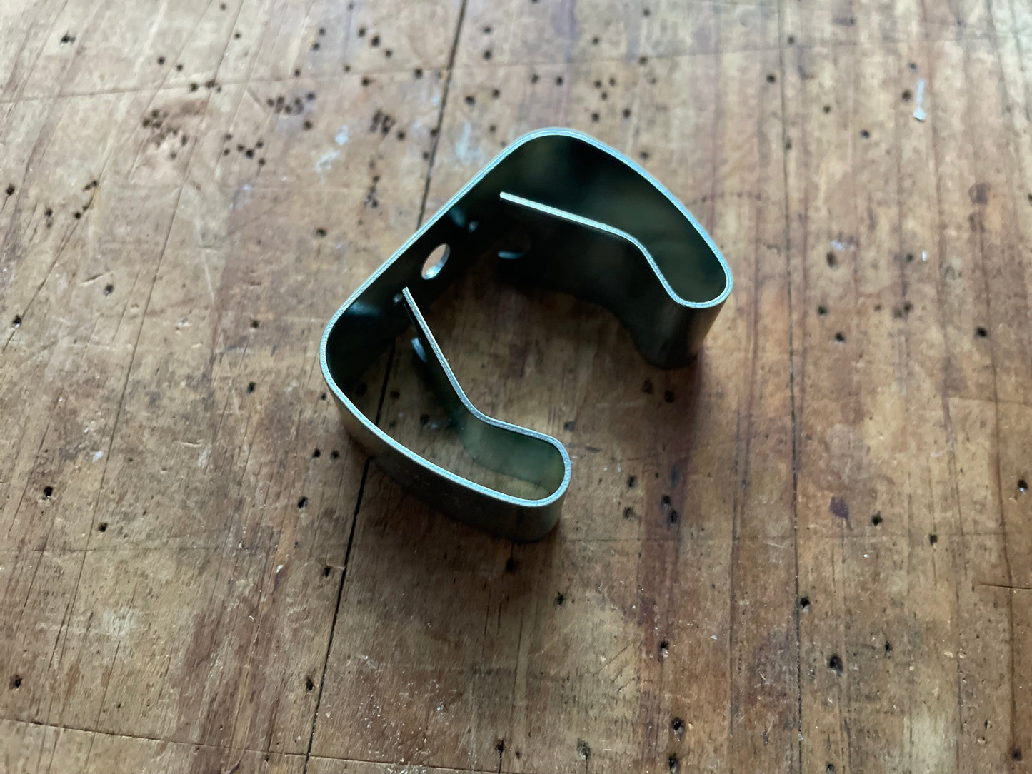 Metal broom holder (vintage) on a wooden surface