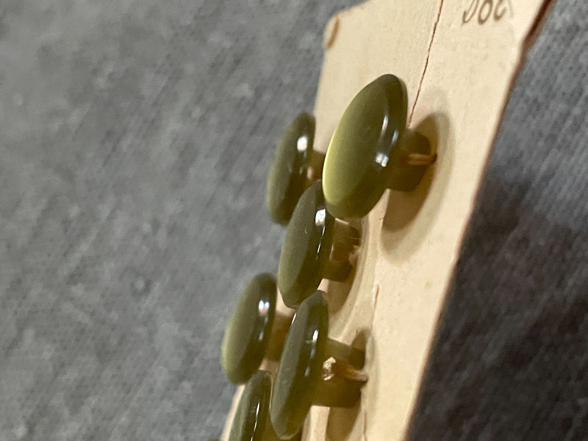 Close-up detail of 8 green la mode shank sewing buttons, 7/16 inch, nos on card