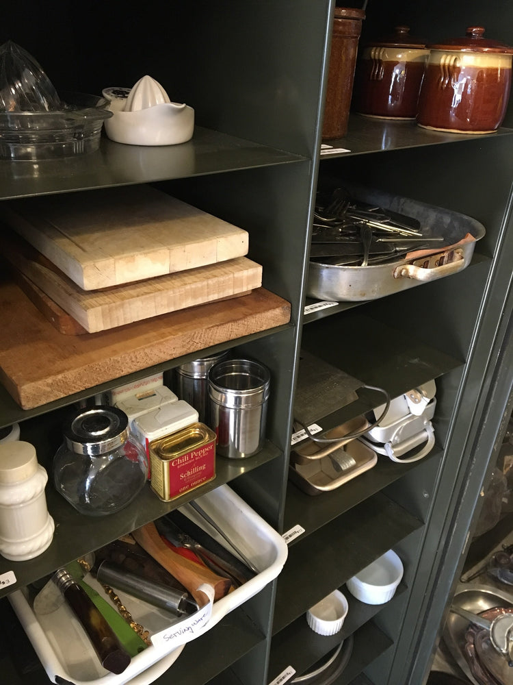 Assorted vintage kitchen utensils, serving pieces, and barware displayed inside the original Junket shop.