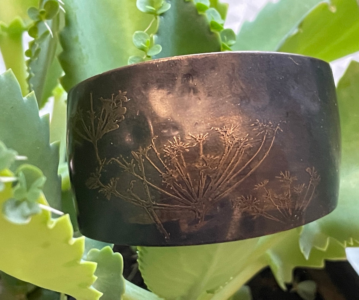 Vintage wide dark patinated metal cuff bracelet with etched wildflower decoration, hero view