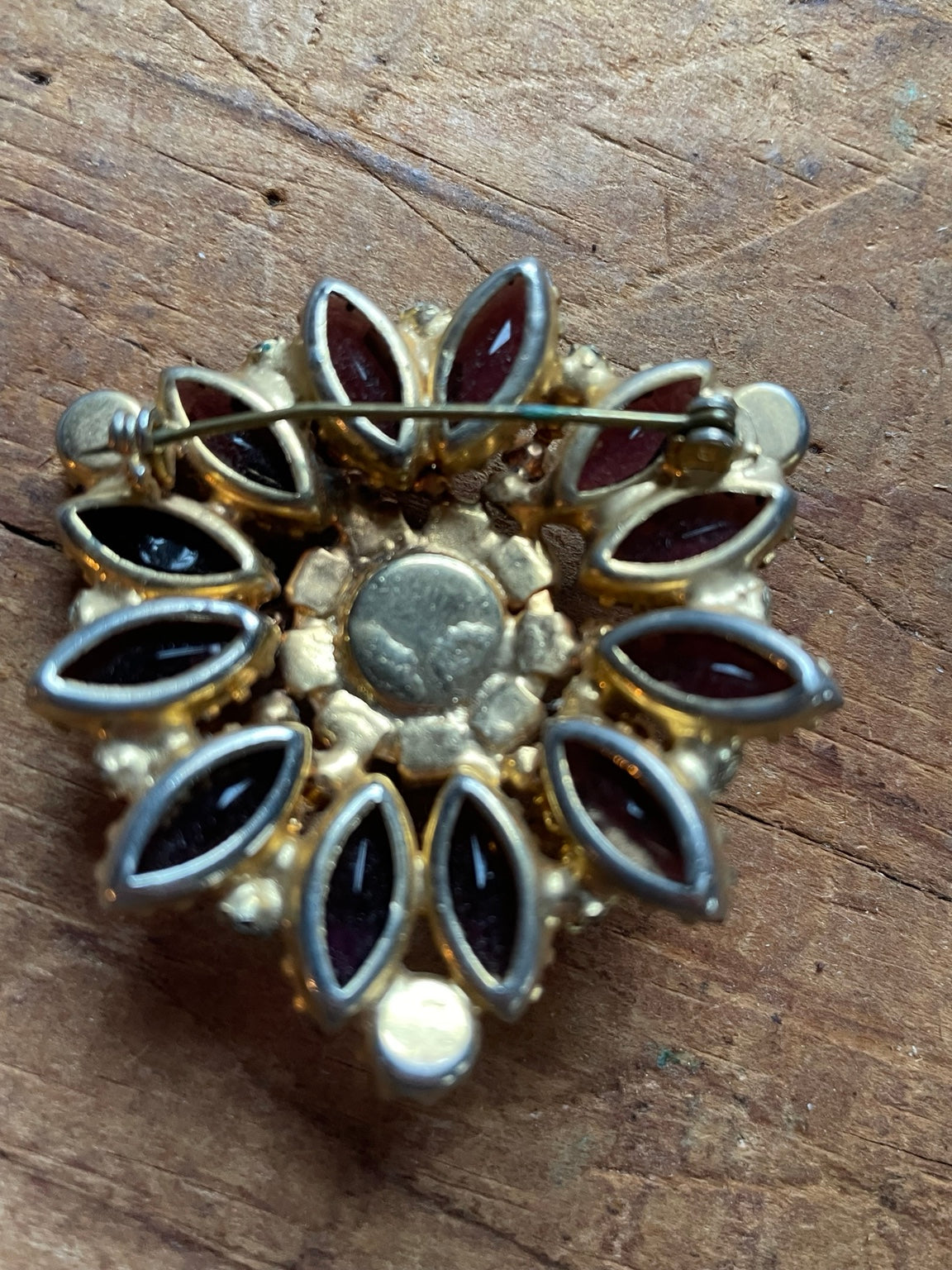Back of vintage purple rhinestone cluster brooch showing pin clasp