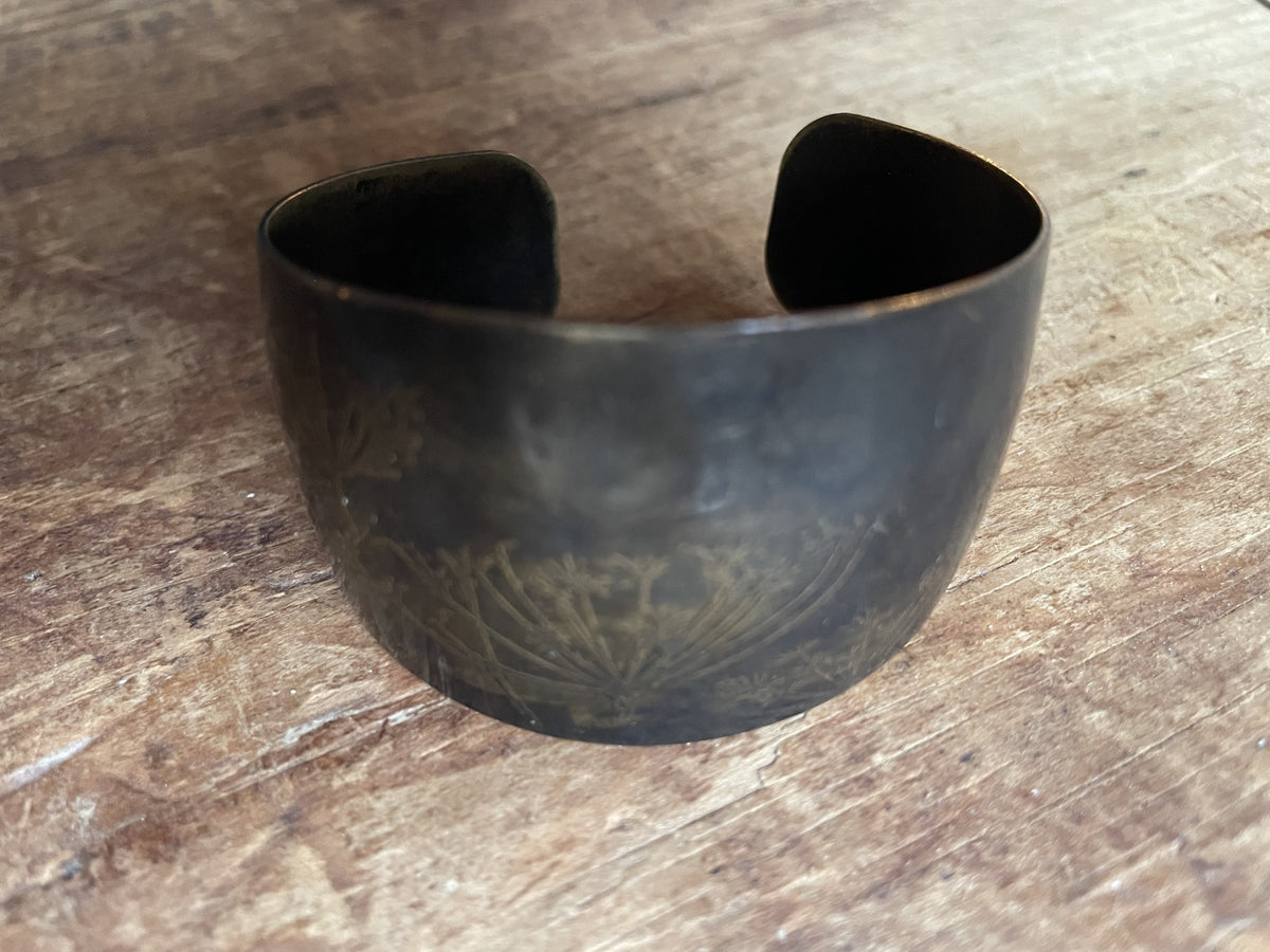 Front view of vintage wide cuff bracelet with etched botanical decoration