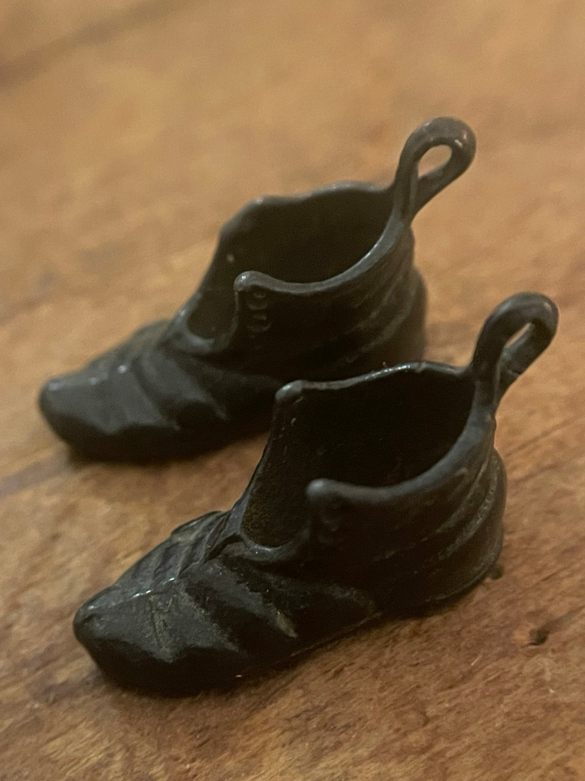 Vintage miniature boot charms showing hollow open interiors and hanging loops