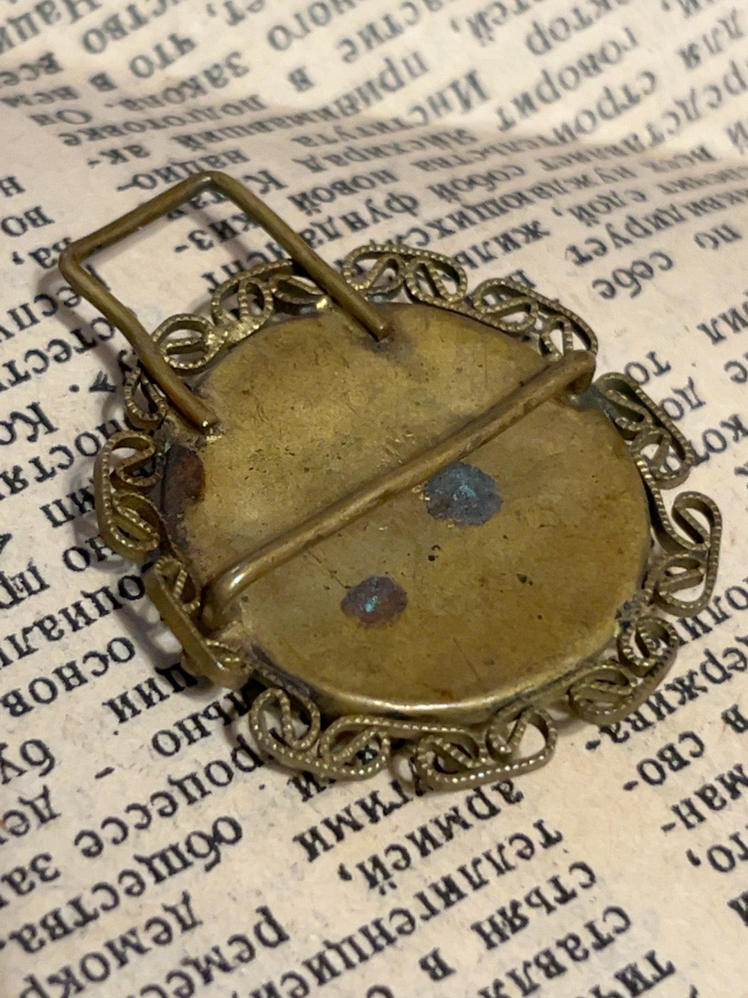 Reverse of vintage iridescent glass and brass-tone filigree accessory