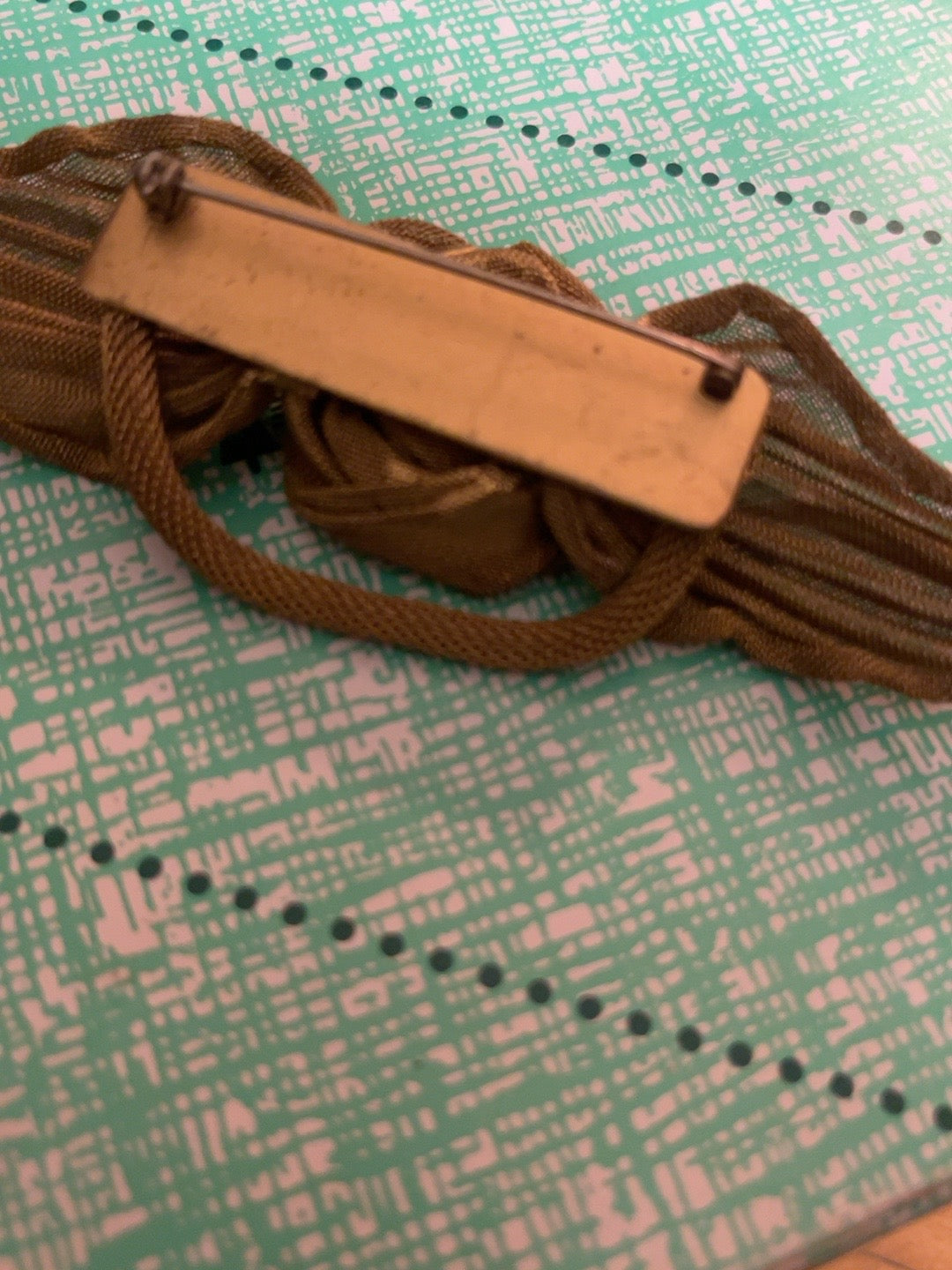 Reverse of oversized vintage metal mesh rose brooch showing rectangular pin bar