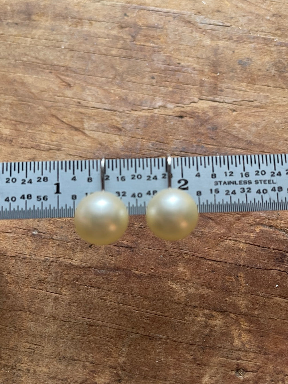 Vintage Trifari faux pearl clip-on earrings shown with ruler for size