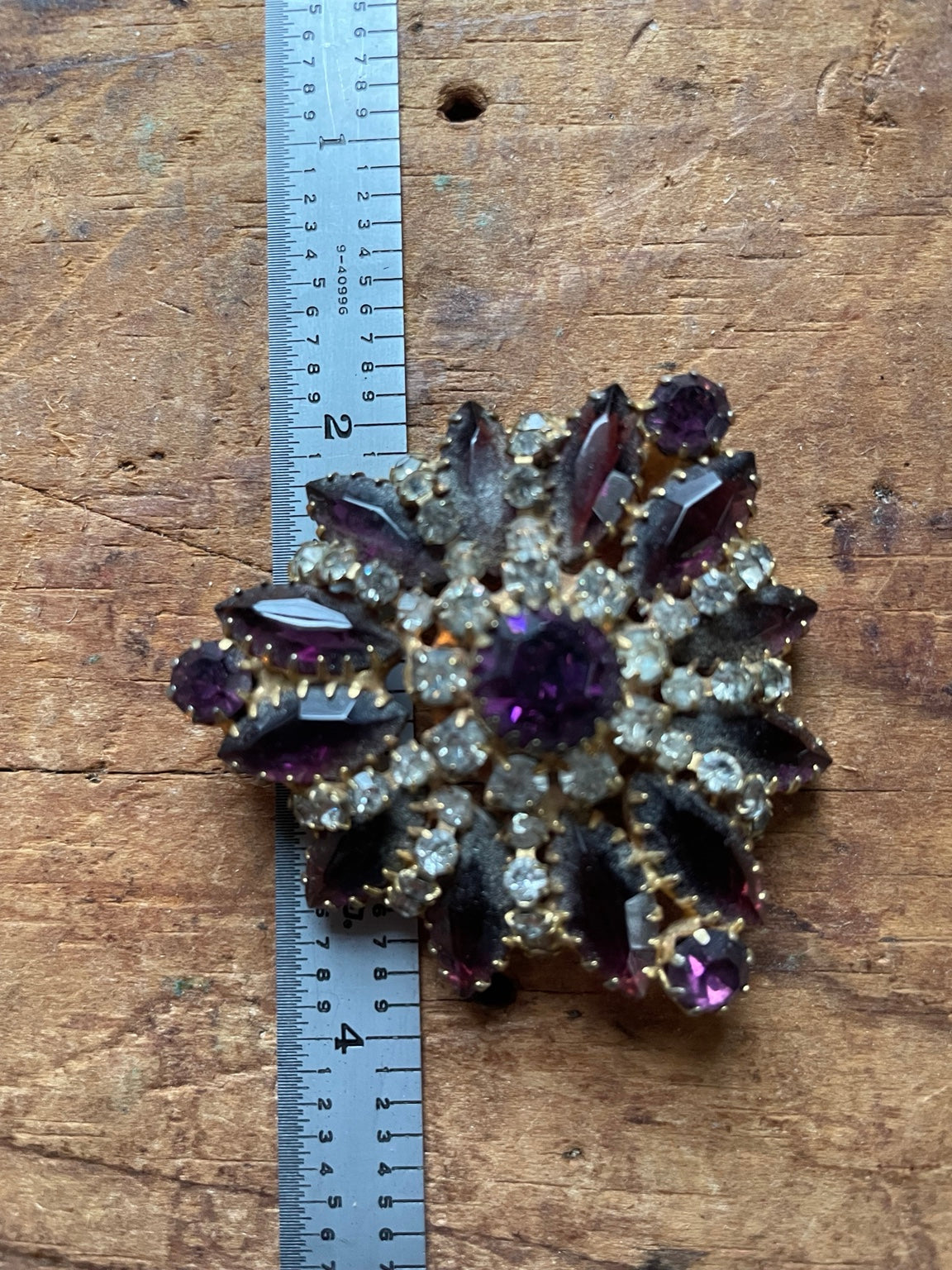 Vintage purple rhinestone cluster brooch shown with ruler for size