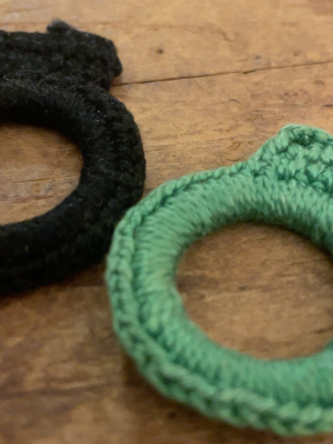 Close detail of textile wrapping and crochet-like edging on mint-green ring pin