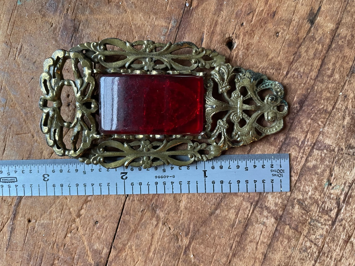 Vintage red glass brooch shown with ruler for length