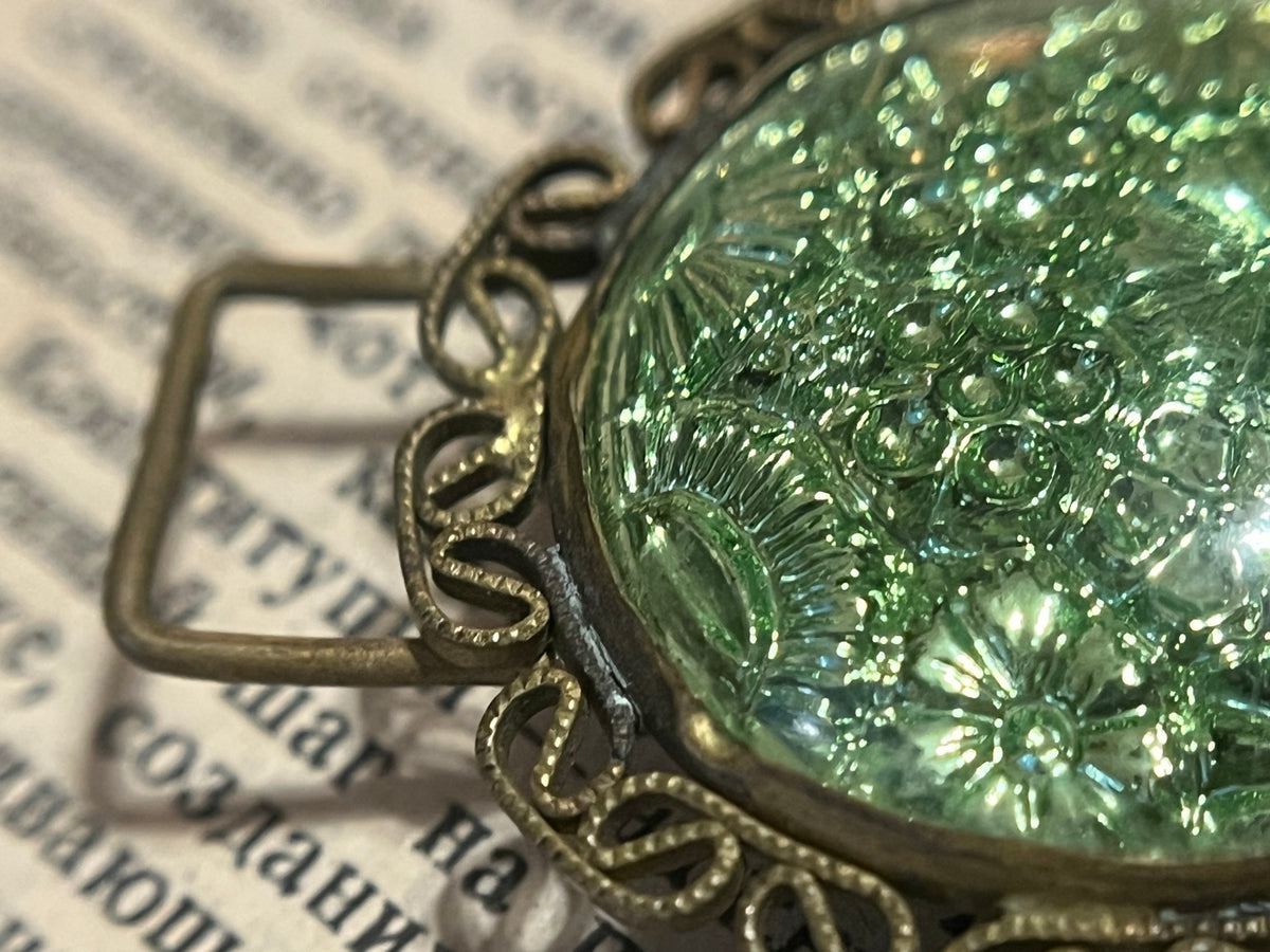 Close detail of iridescent floral glass and brass-tone filigree construction