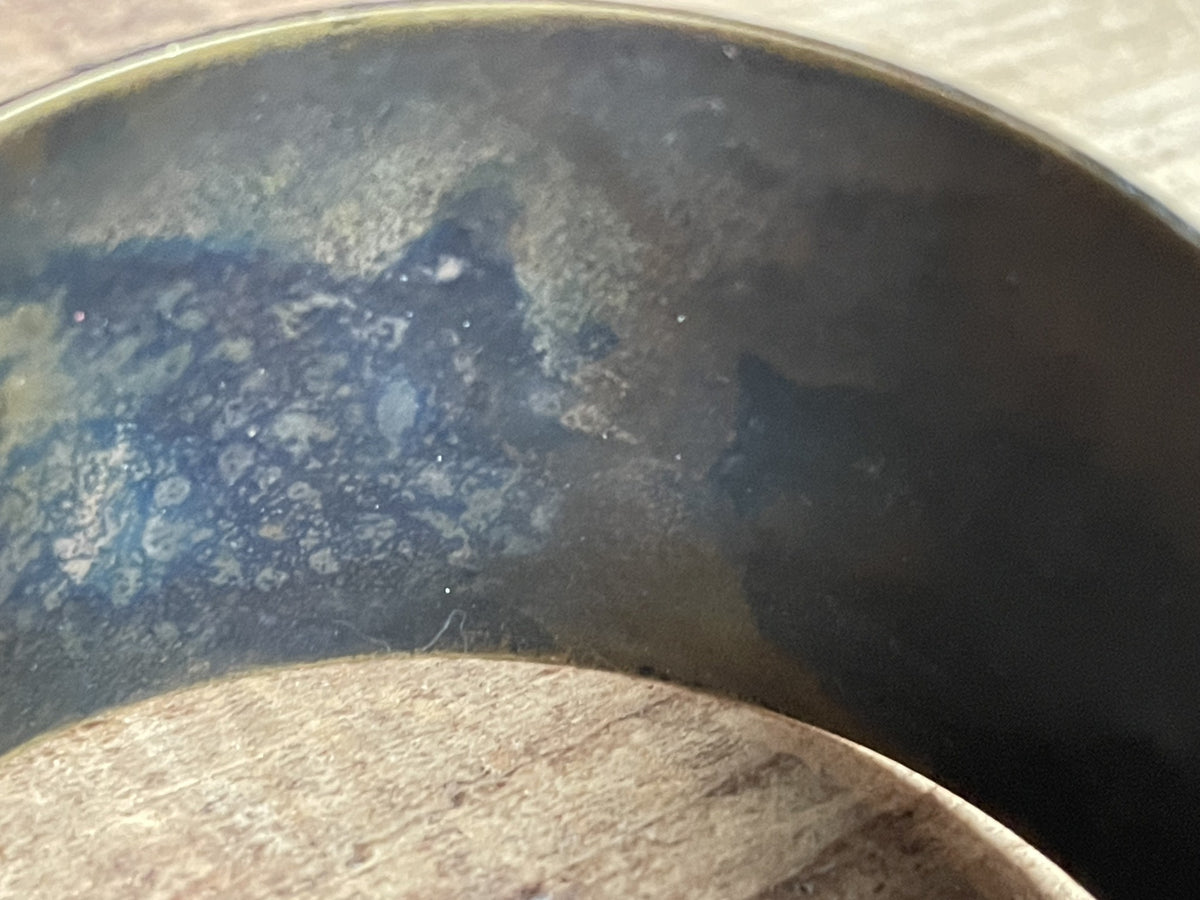 Interior of vintage etched cuff bracelet showing dark patina and surface wear
