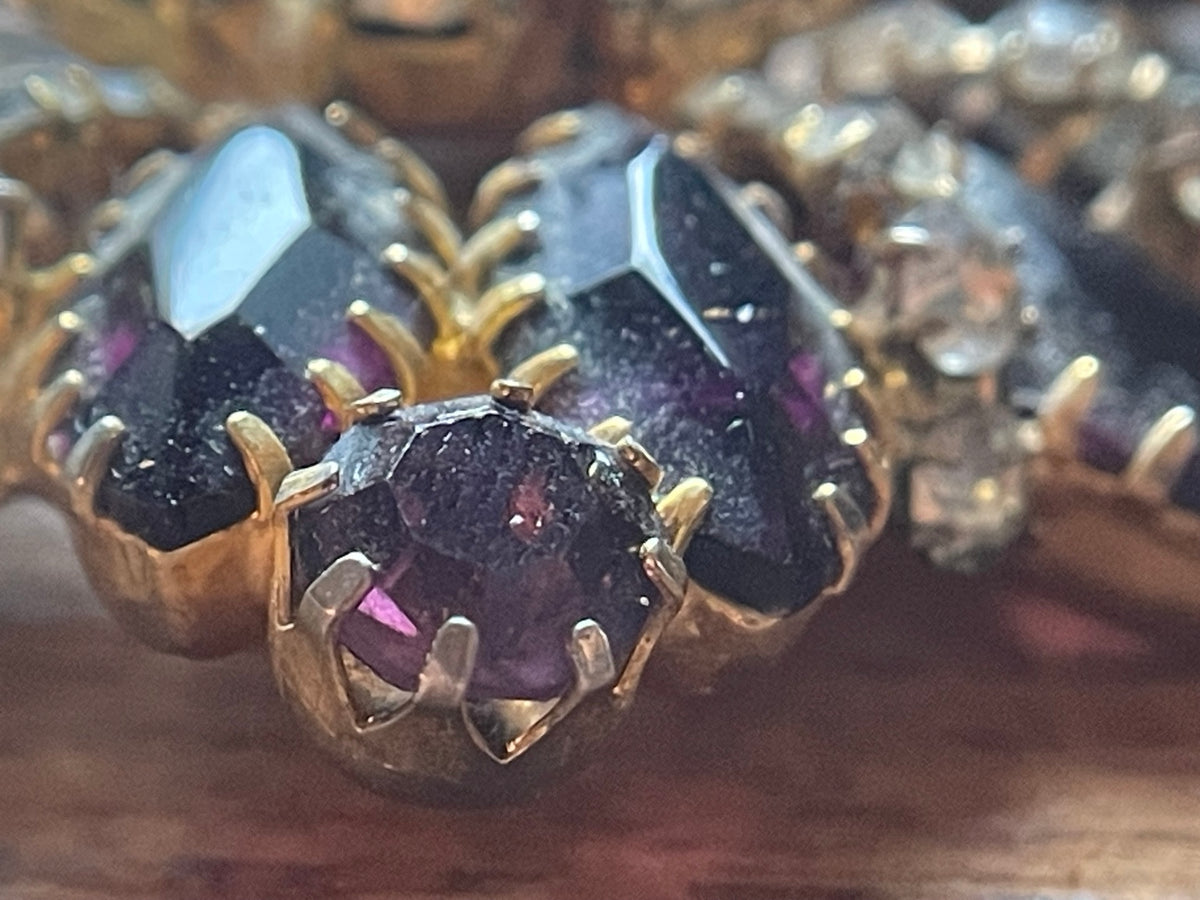 Close-up of faceted deep-purple glass stones in vintage cluster brooch