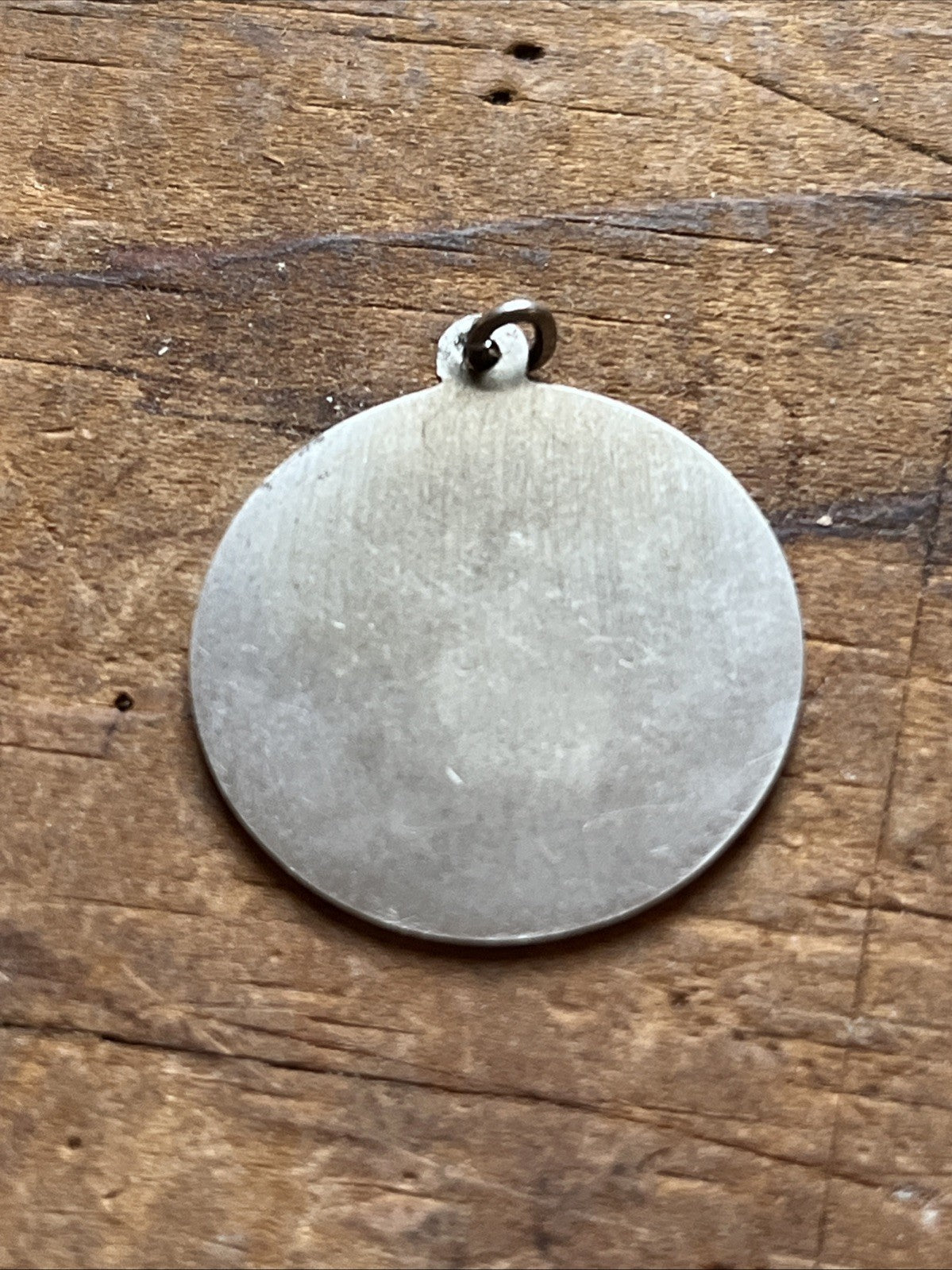 Plain reverse of a round silver-colored bridal charm