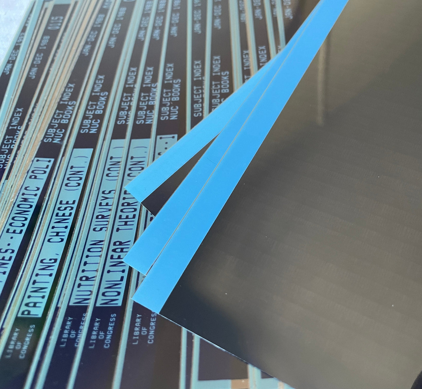 Closeup of blue-trimmed vintage microfiche film sheets photographed in natural light.