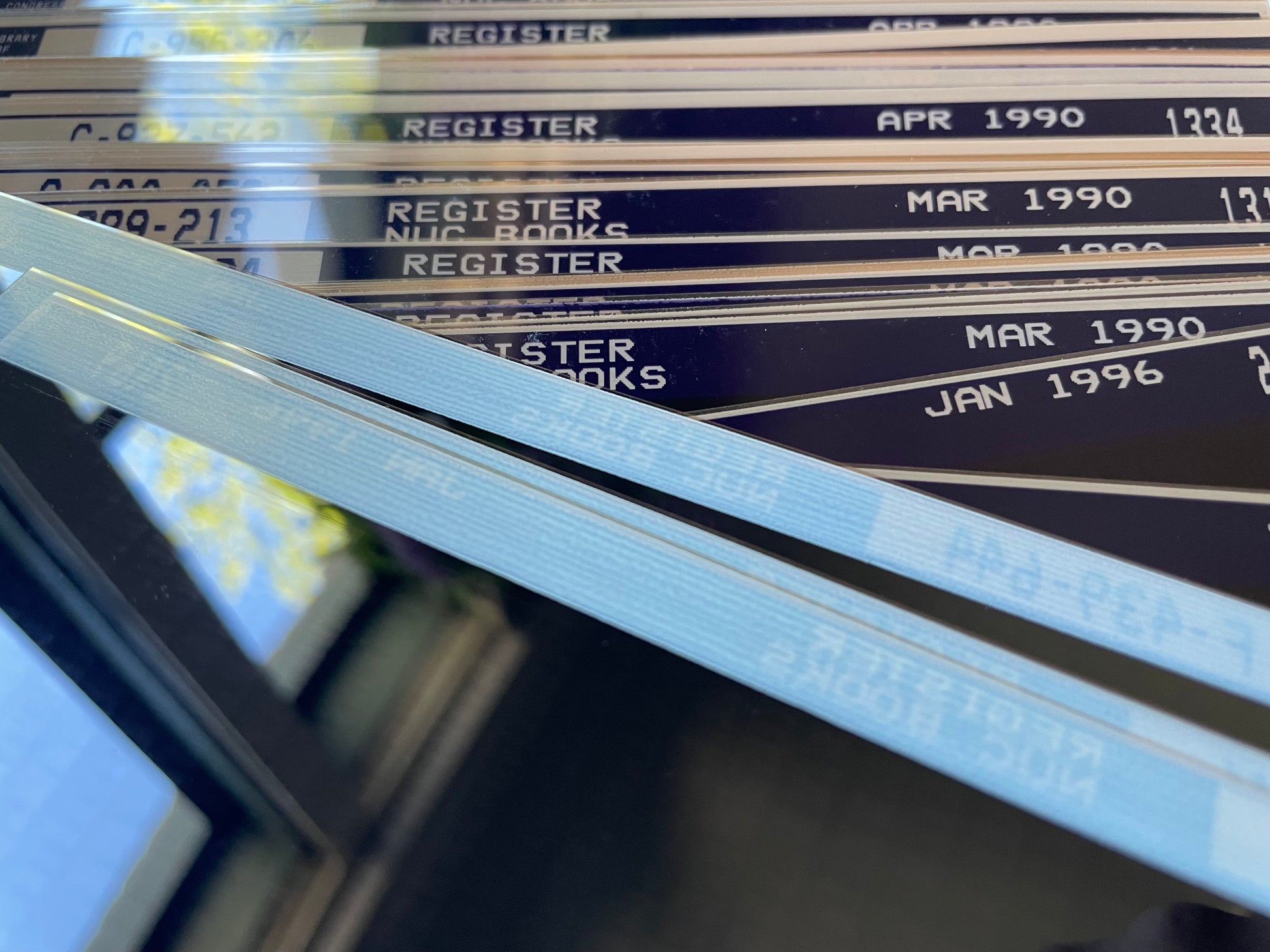 Closeup of peach & white-trimmed vintage microfiche film sheets photographed in natural light.