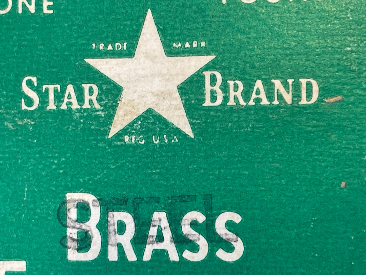 A close-up of a green vintage Star Brand package featuring the Star Brand logo/trademark and the word 'Brass' in white - overstamped in black ink with the word 'Steel.'
