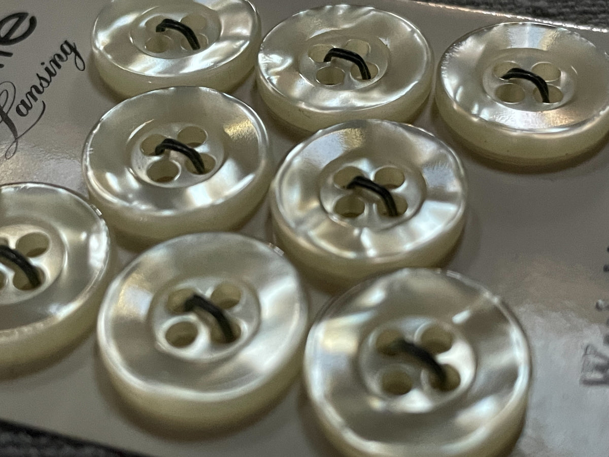 Close-up detail of 8 pale la petite four-hole sewing buttons, 13.5 mm, nos on card