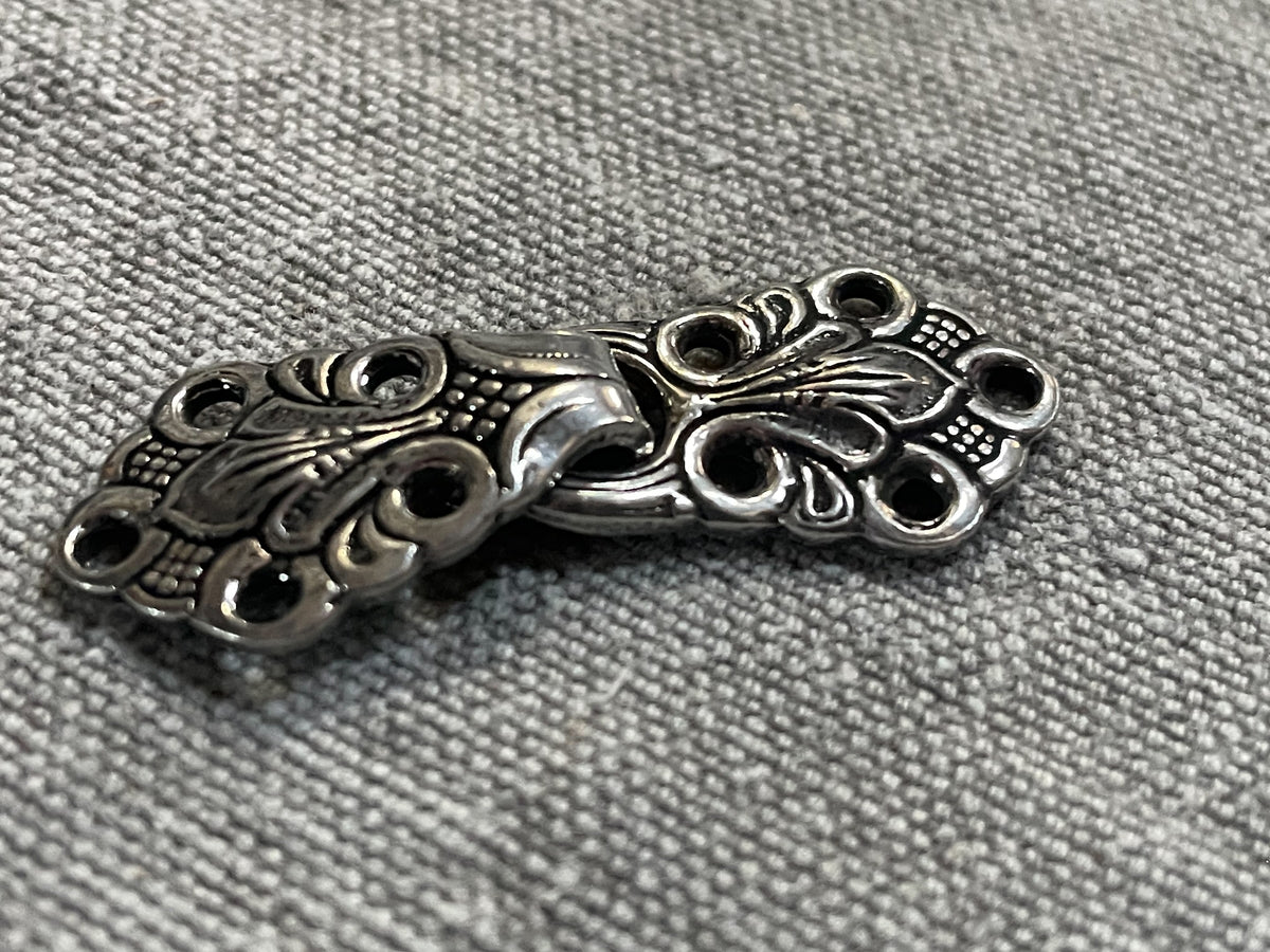 Angled close-up of norwegian-style silver-tone sweater hook-and-loop closure, 45 mm