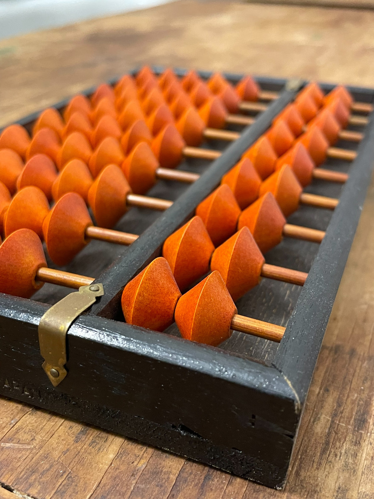 Close-up of orange soroban beads, rods and metal center marker