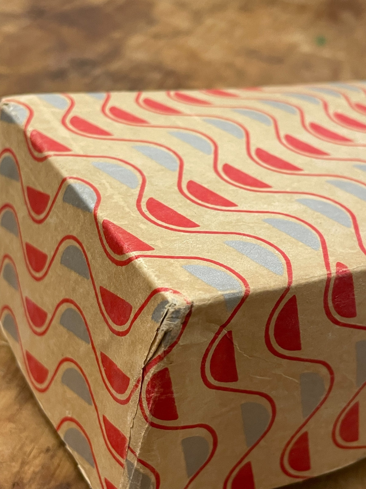 Close-up of patterned paper and corner wear on vintage presentation box