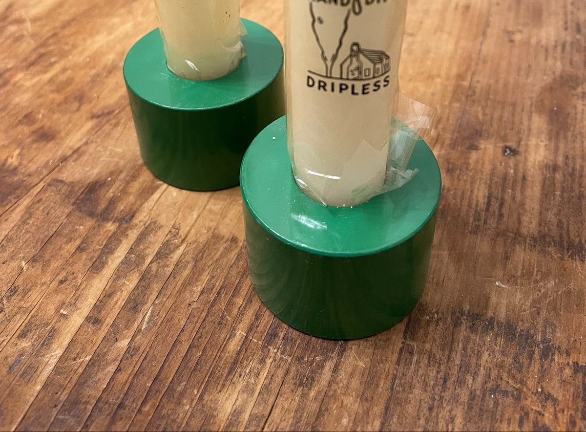 Pair of green taper candle holders holding long matches for scale and styling