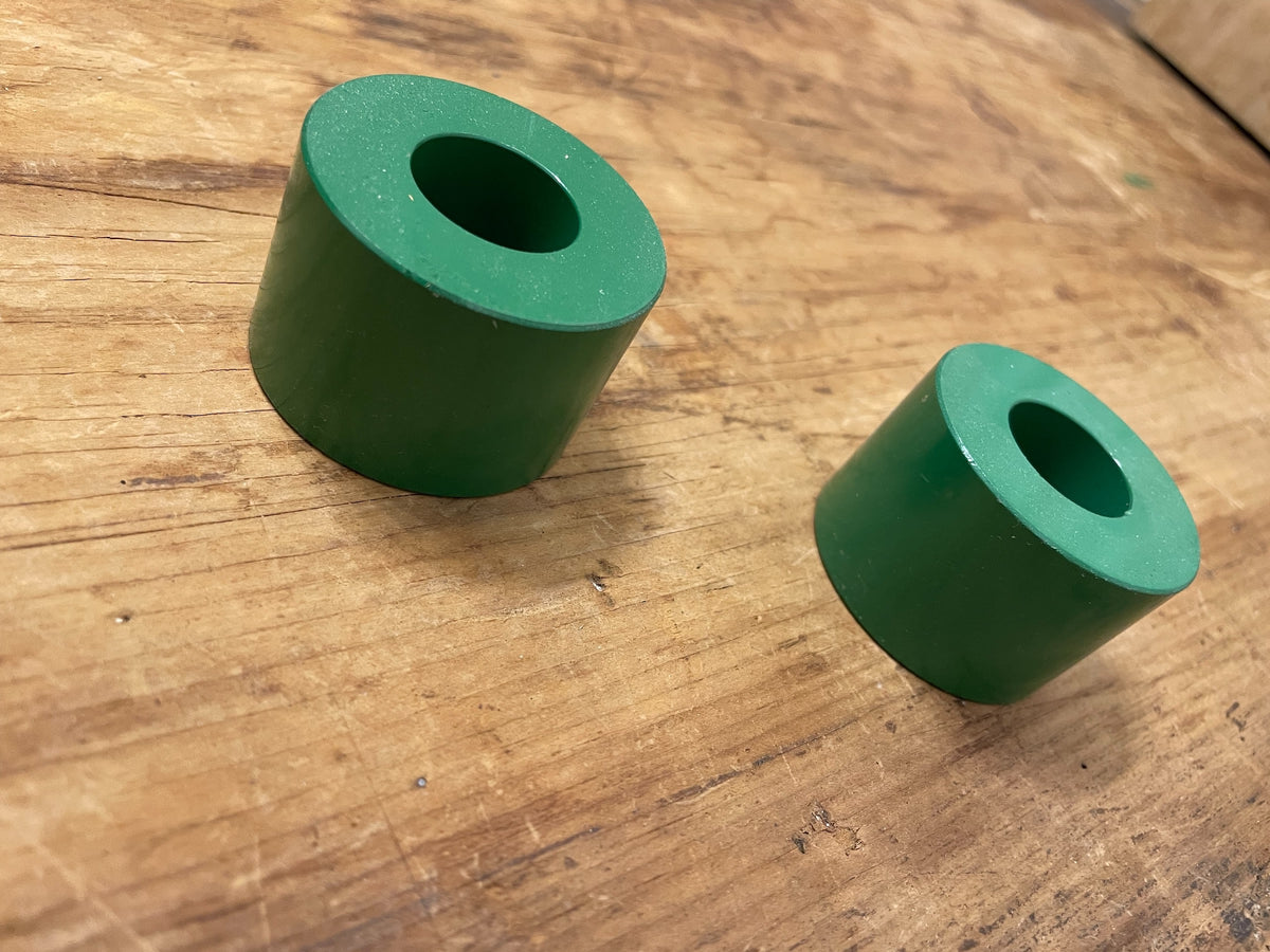 Pair of vintage green cylinder taper candle holders on wood surface