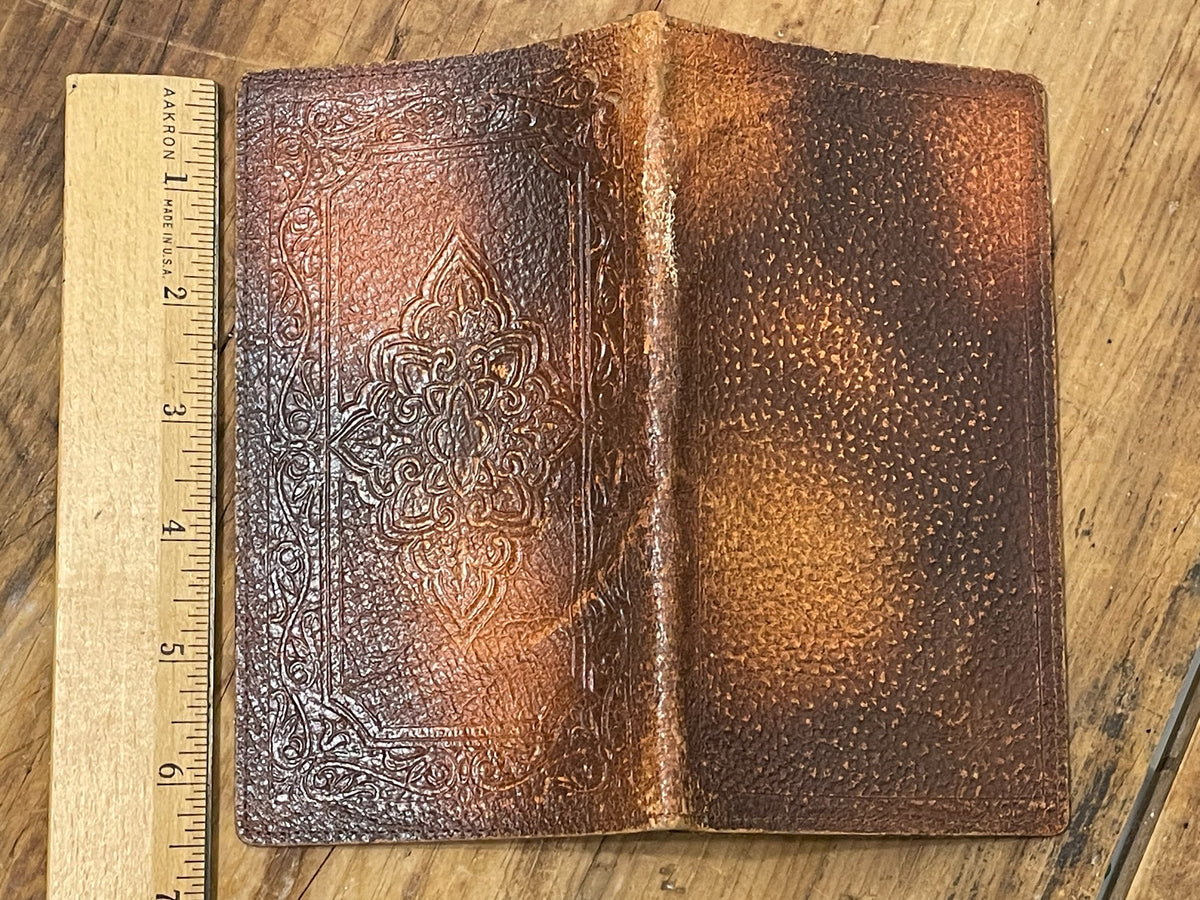 Open vintage brown leather advertising wallet showing interior pockets