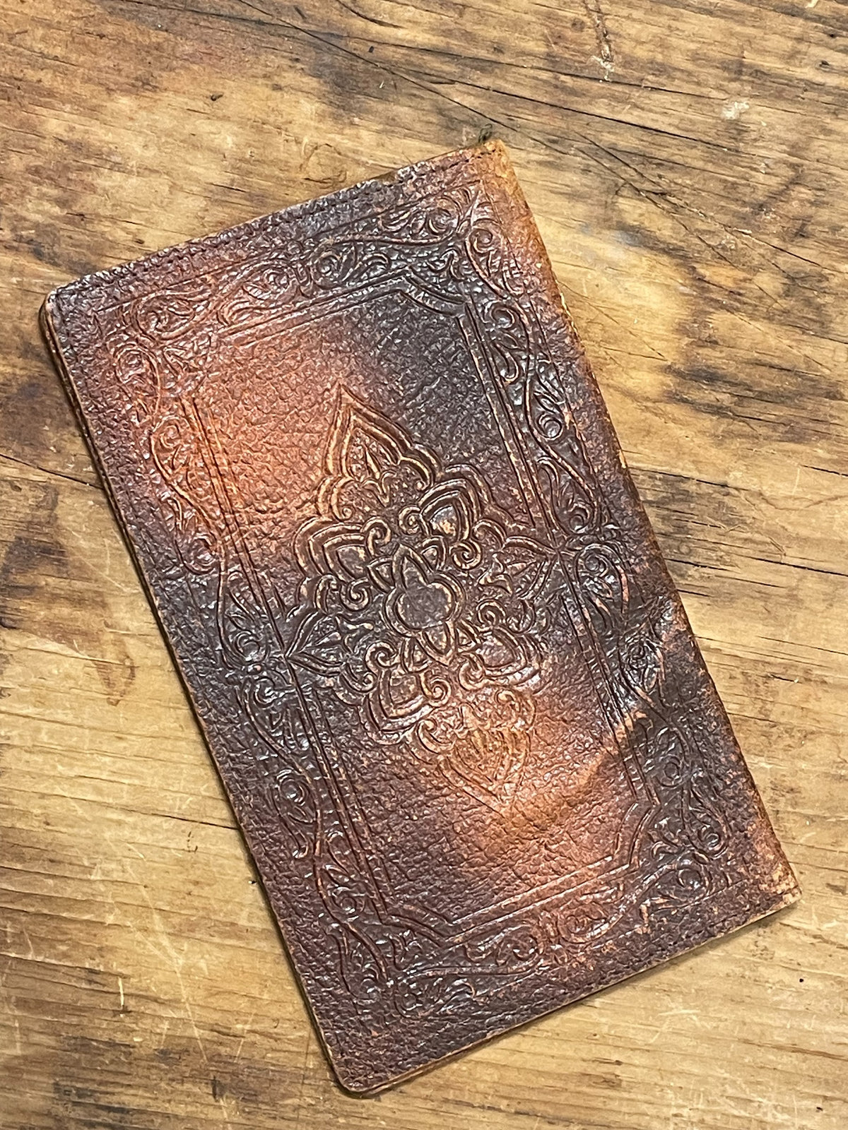 Closed vintage brown embossed leather advertising wallet
