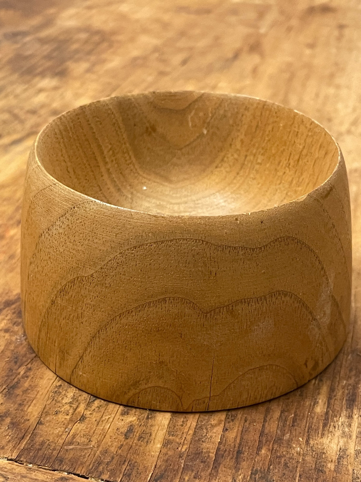 Angled exterior view of hand-turned rustic wood bowl with natural grain