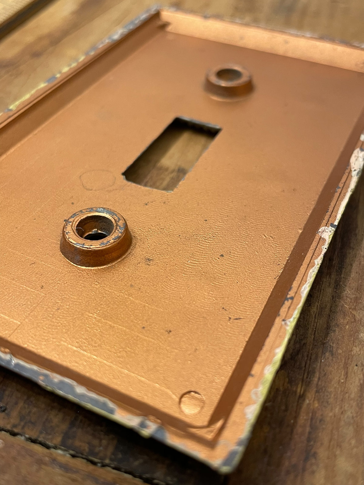 Back of vintage molded plastic toggle switch plate showing screw bosses