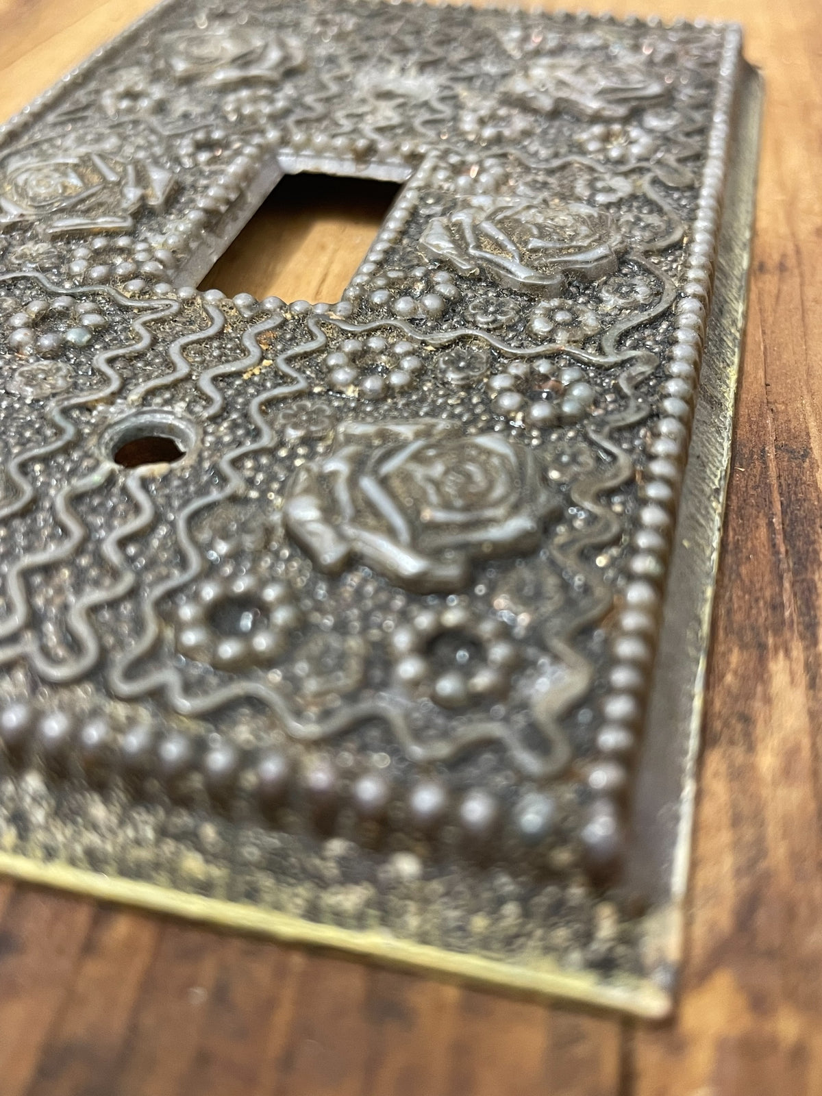 Close-up of raised floral and geometric ornament on vintage switch plate