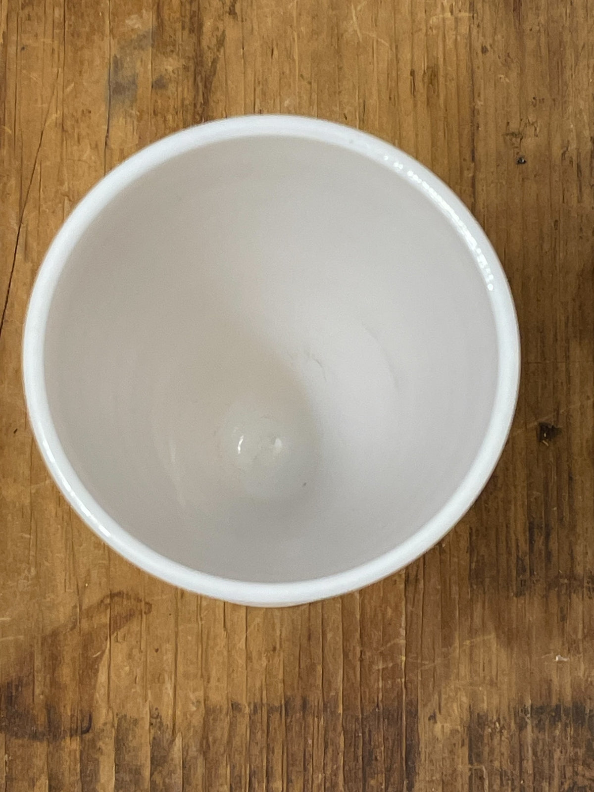 Top view into vintage white milk glass footed cup