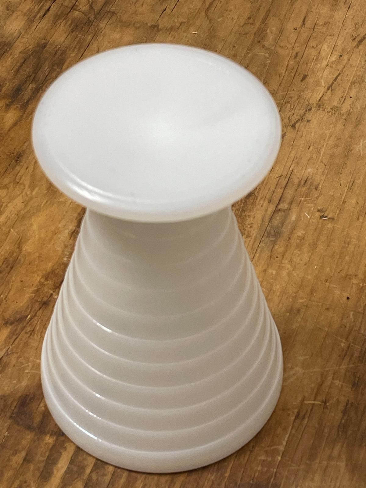 Side view of vintage ribbed white milk glass pedestal cup