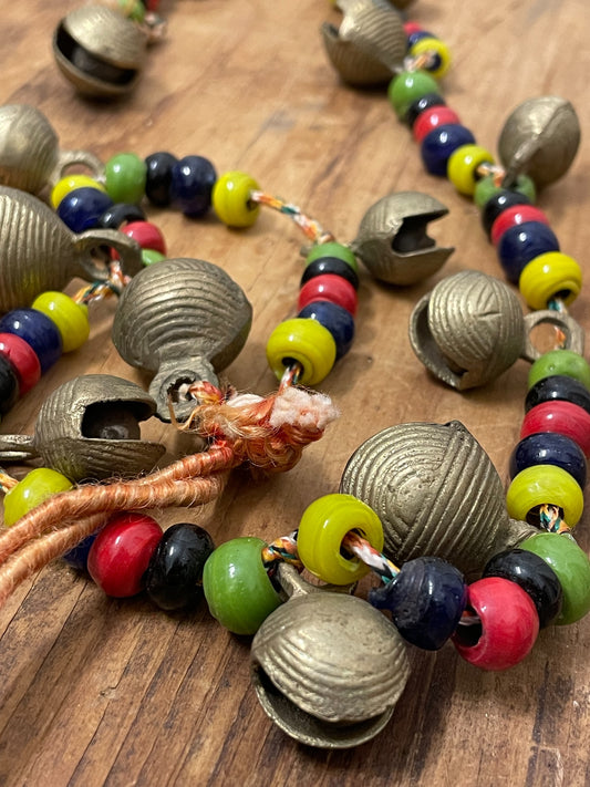 Close-up of colorful beads and cast metal bells on vintage bell garland