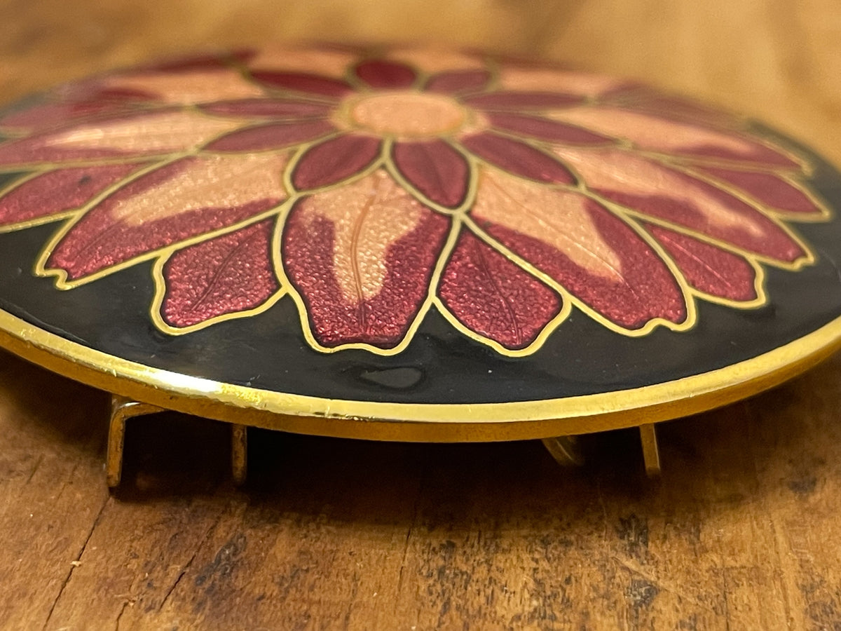 Side profile of round floral enamel belt buckle showing raised construction