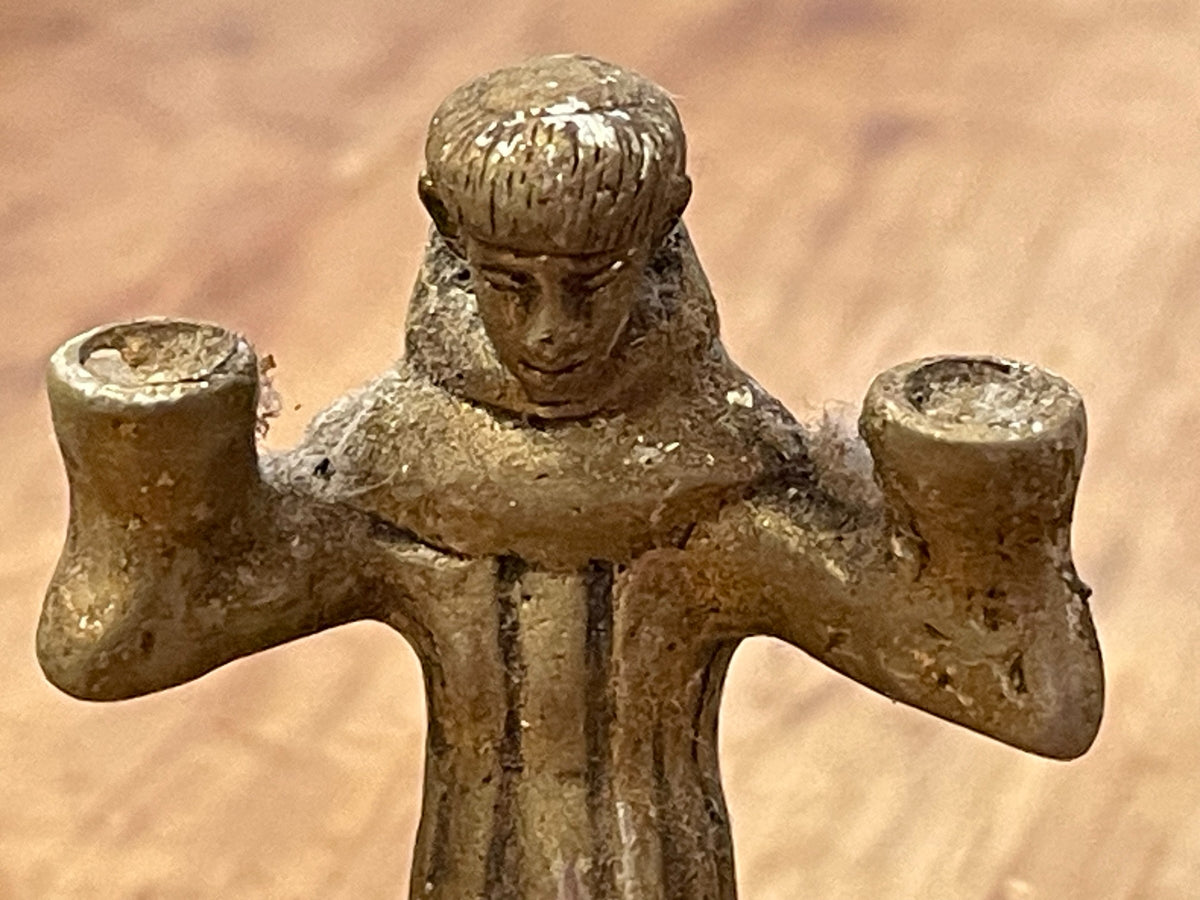 Close-up of figure's face and two small candle sockets