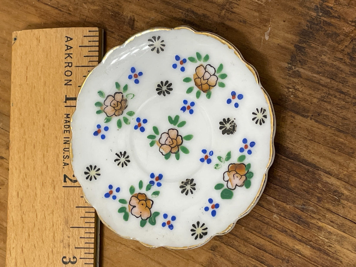 Miniature Japan porcelain floral plate beside ruler for scale