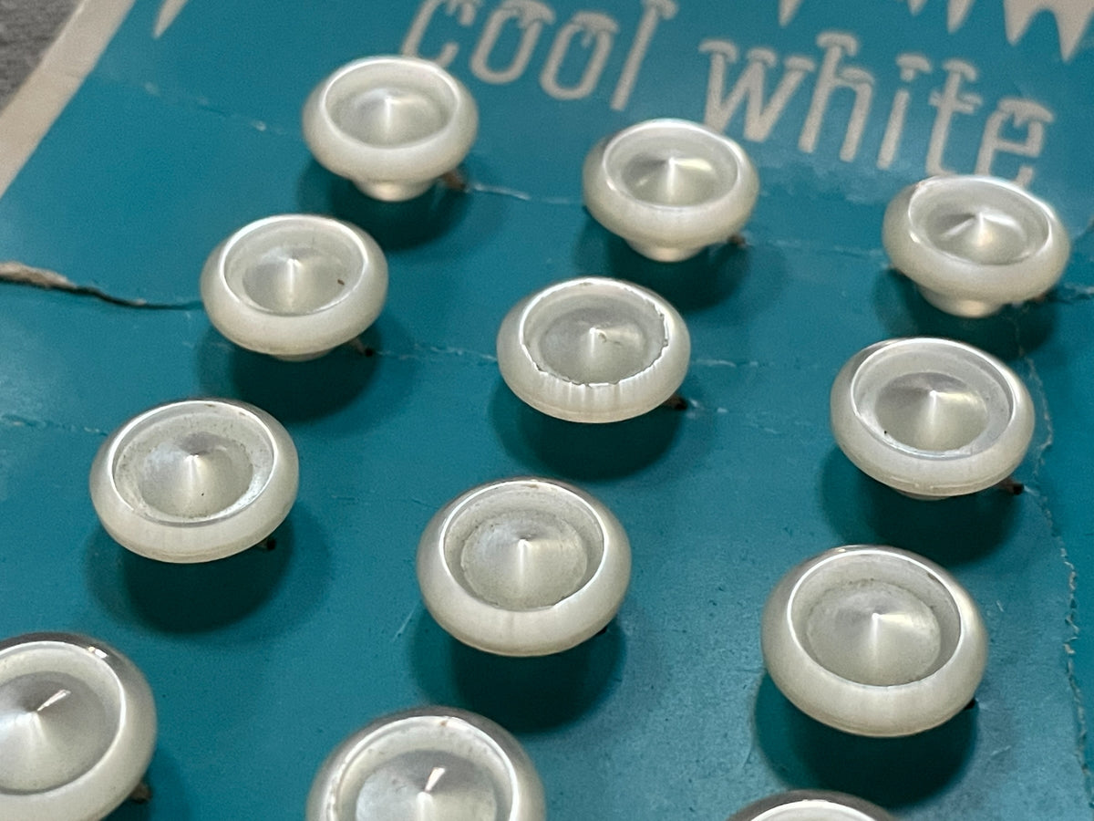 Close-up detail of 12 cool white le chic sewing buttons, 7/16 inch, nos on card