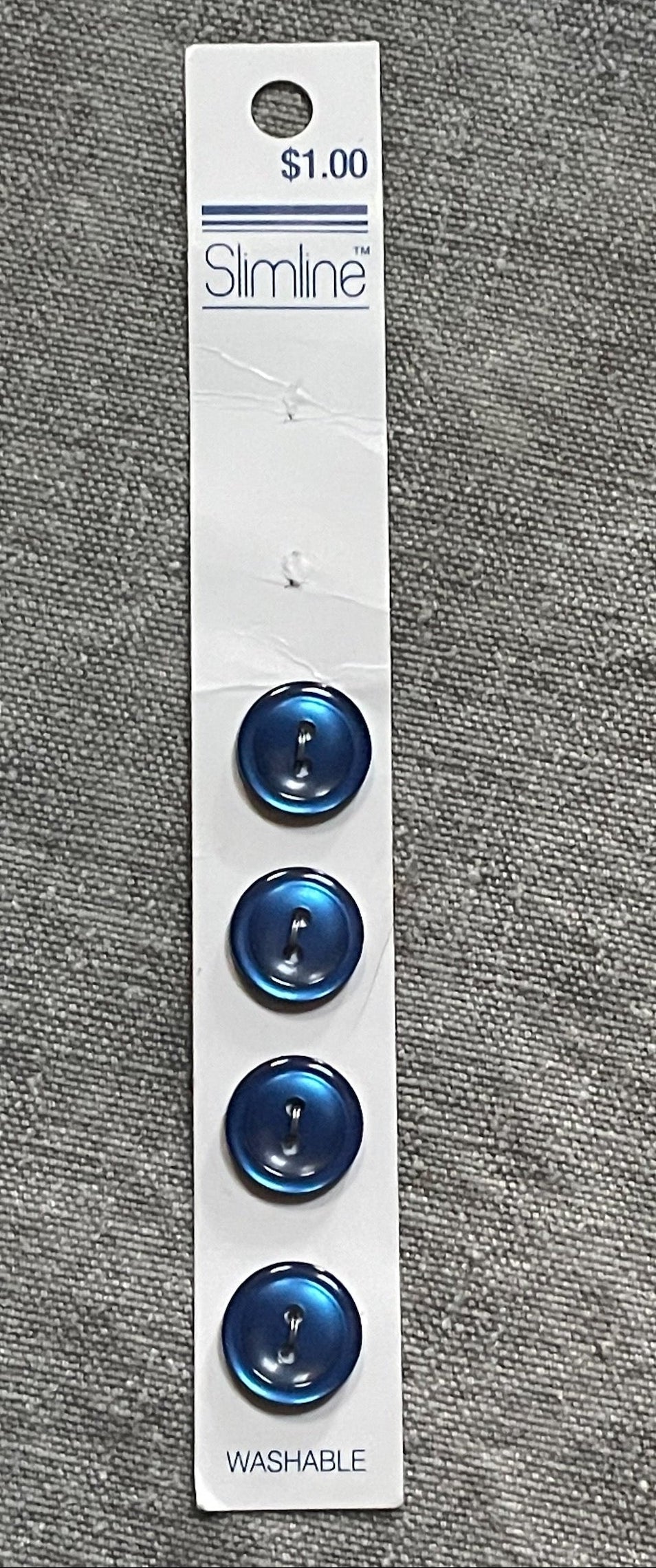Product view of 4 navy blue slimline two-hole sewing buttons, 13.91 mm, original card