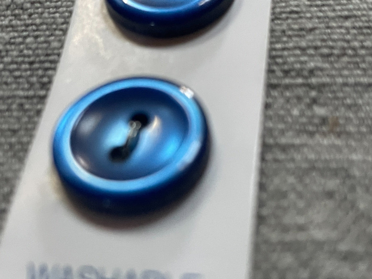 Close-up detail of 4 navy blue slimline two-hole sewing buttons, 13.91 mm, original card