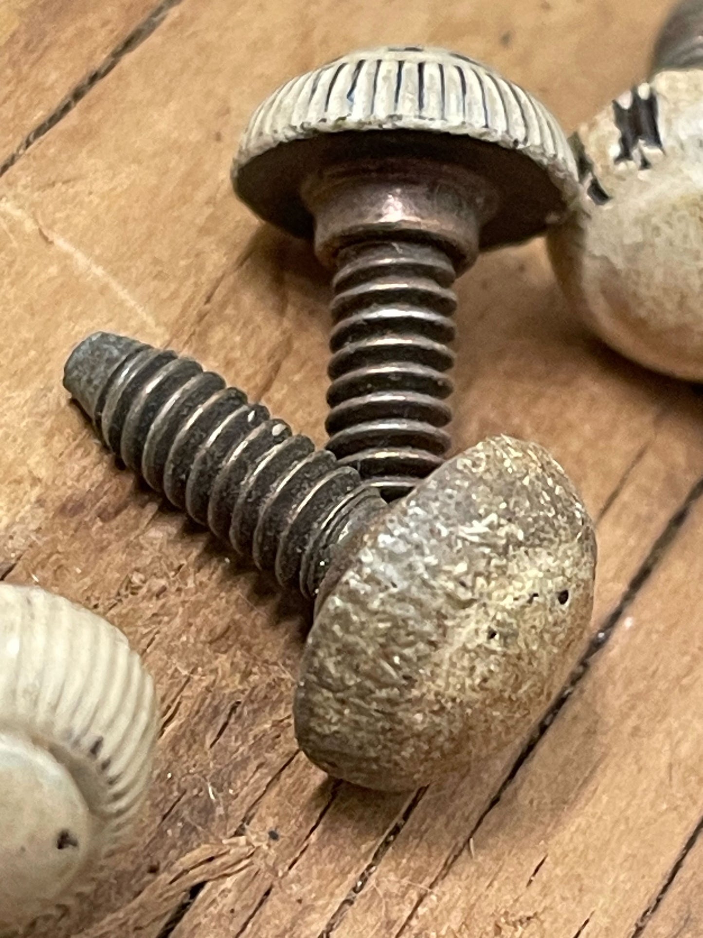 Extreme closeup of antique screws with heavy patina on a wooden background 