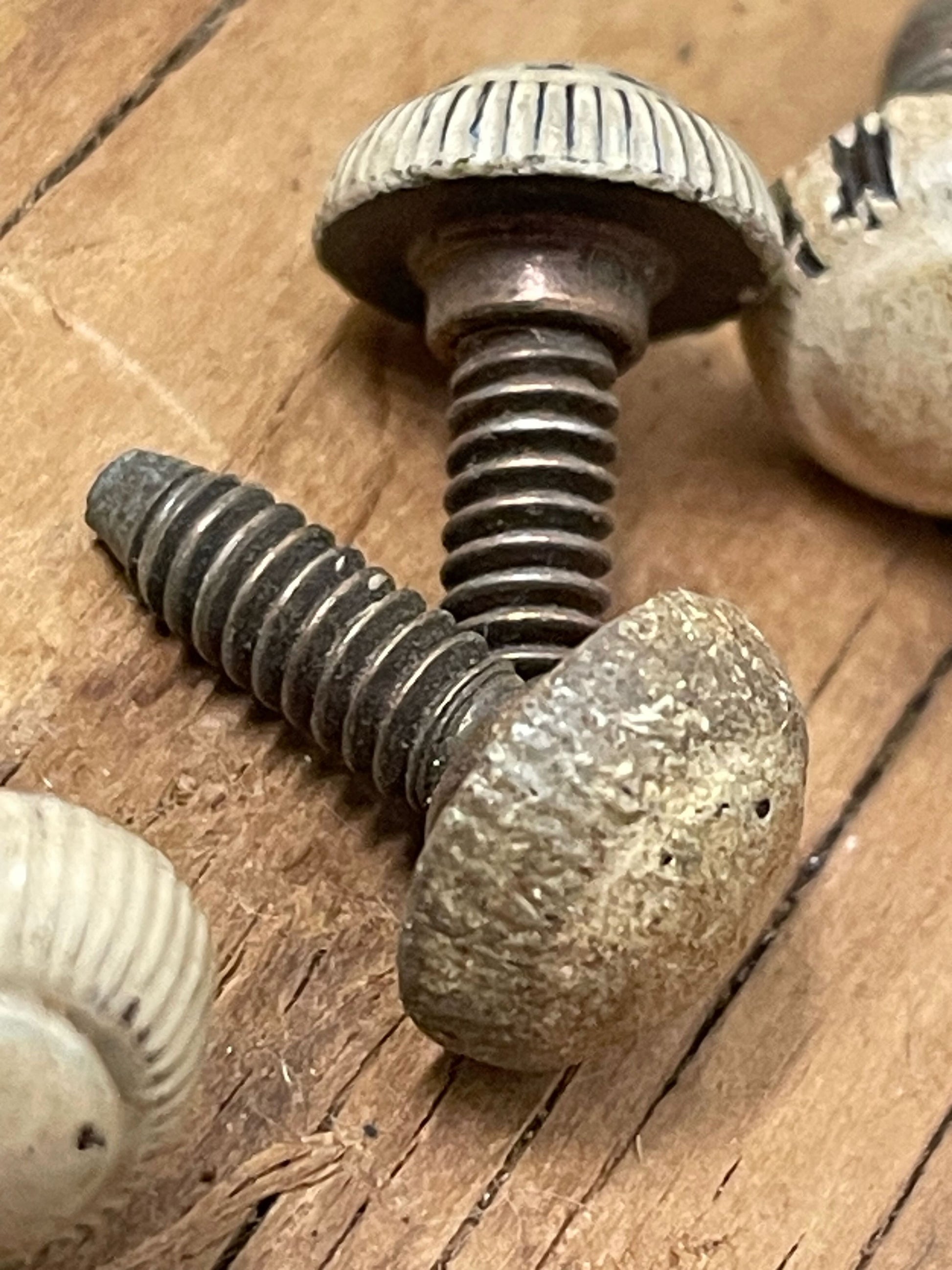 Extreme closeup of antique screws with heavy patina on a wooden background 