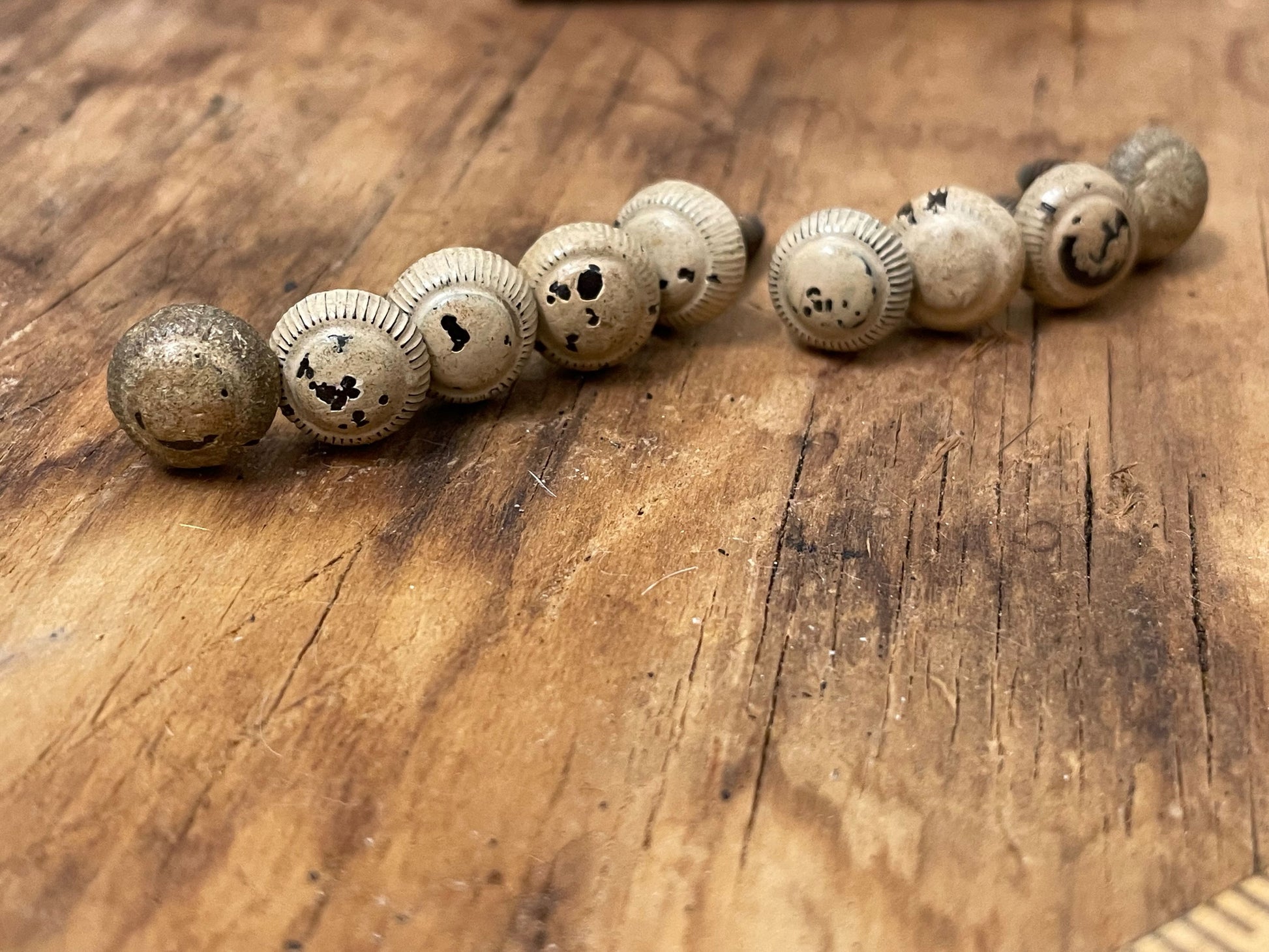 Set of nine antique screws with heavy patina on a wooden background 
