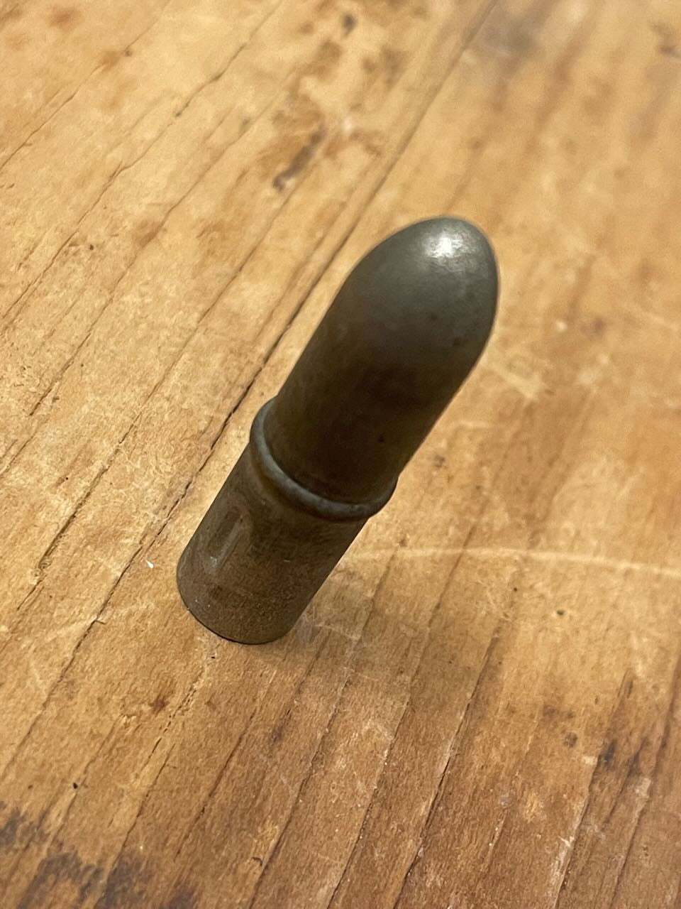 Metal pencil topper on a wooden surface