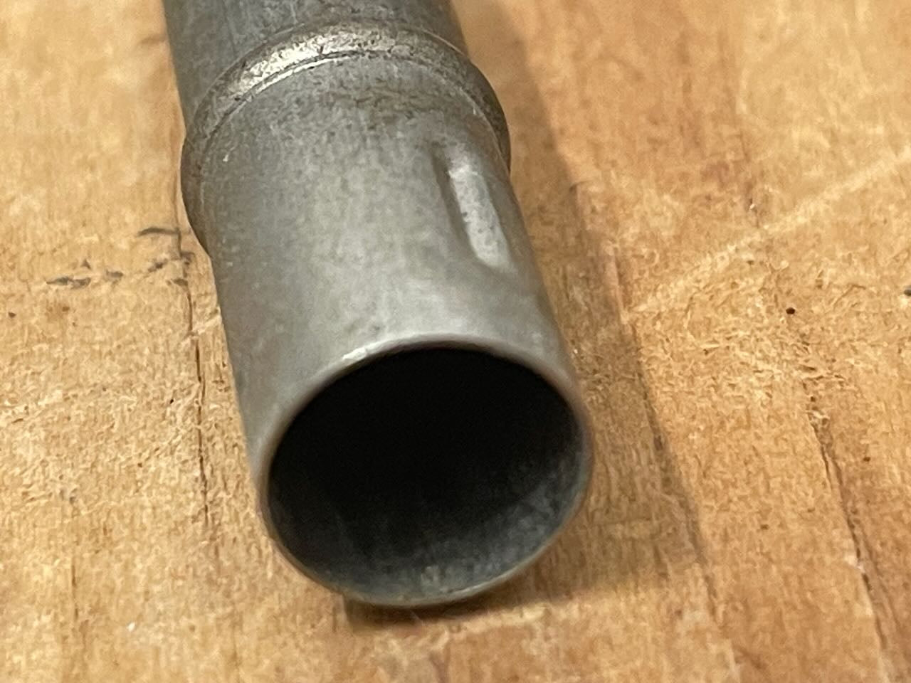 Metal pencil topper on a wooden surface