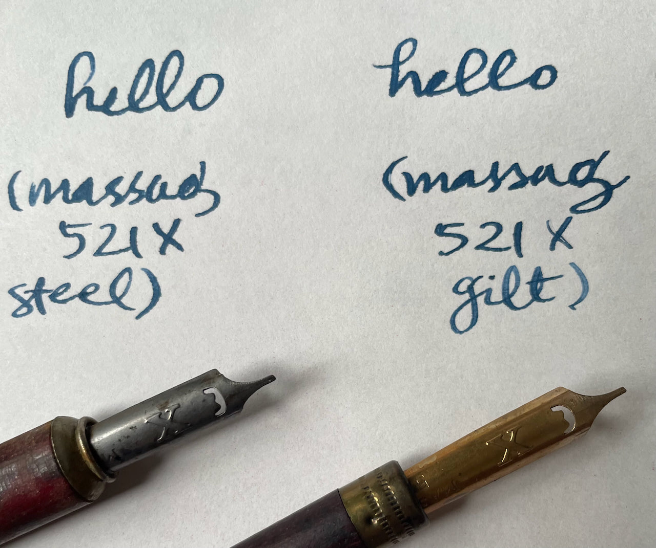 Two pen nibs with writing samples on a white background