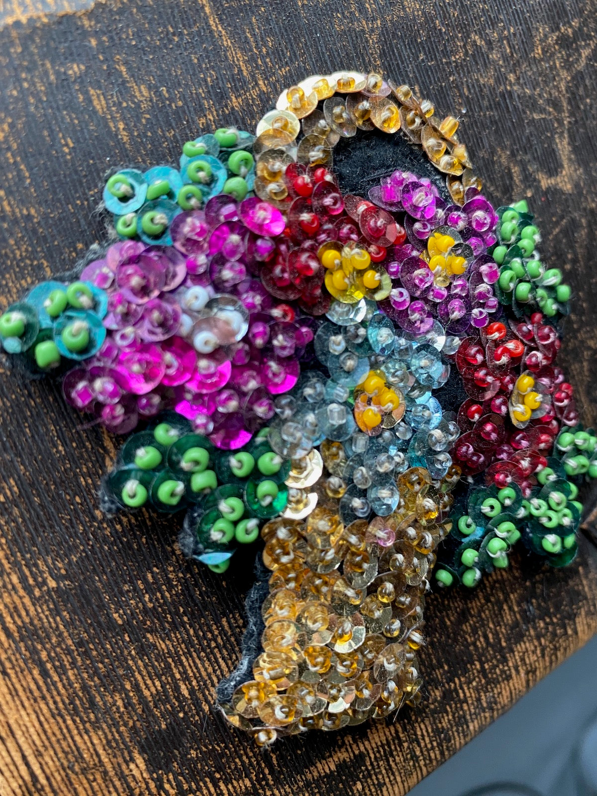 Colorful beaded brooch on a wooden surface